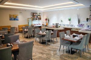 a restaurant with tables and chairs in a room at فندق ليان بارك Lian Park Hotel in Al Khobar