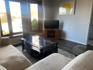 a living room with a tv and a coffee table at Napaeno's Place - Home Away from Home in Kingston
