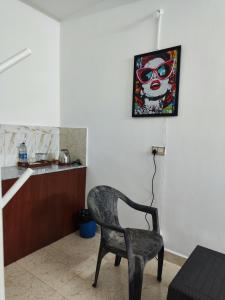 a chair in a room with a picture on the wall at Quiet Coastal Hideaway Studio near Candolim Beach in Candolim
