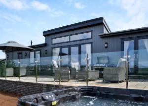 a house with glass walls and a swimming pool at Penally Grange in Tenby