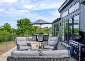 a patio with a table and chairs and an umbrella at Penally Grange in Tenby