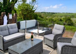 a patio with chairs and a bottle of wine on a table at Penally Grange in Tenby