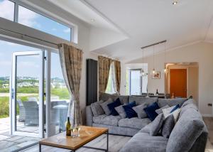 a living room with a couch and a table at Penally Grange in Tenby +46 photos
