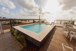 a swimming pool on a deck with a view of the ocean at Xênius Hotel in João Pessoa