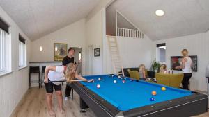 Ein Mann und eine Frau spielen Billard in einem Zimmer in der Unterkunft Villavilla #347 - Dueodde, Bornholm in Bedegård