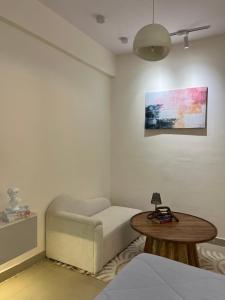 ein Wohnzimmer mit Sofa und Tisch in der Unterkunft The Elysian in Ghaziabad