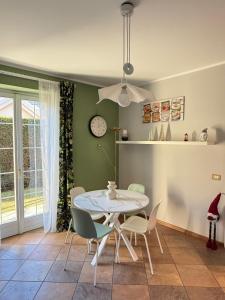 una sala da pranzo con tavolo, sedie e orologio di Dimora degli Gnomi a Tirano