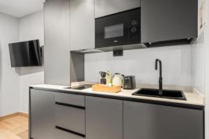 a kitchen with a sink and a microwave at Dobo Madrid Portugal in Madrid