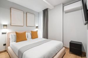 a bedroom with a large white bed with orange pillows at Dobo Madrid Portugal in Madrid