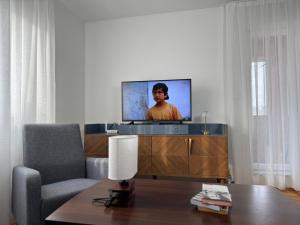 een woonkamer met een tv, een stoel en een tafel bij Odmori se, Centar apartman in Donje Mladice