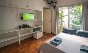 a bedroom with a bed with a tv and a window at Dos Patios - Luz, tranquilidad y verde in La Plata