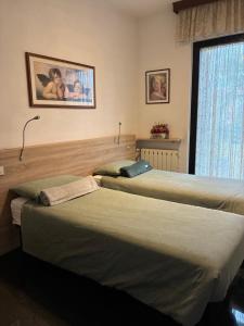 twee bedden in een hotelkamer met een raam bij Affittacamere Lively in Novara +12 foto's