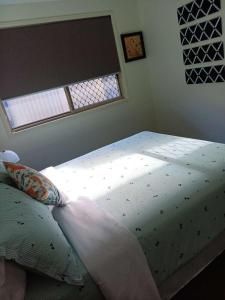 een groot bed in een slaapkamer met een raam bij Victoria Point Queen bed & Breakfast in Victoria Point