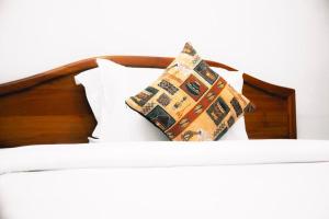 un letto con due cuscini sopra di Arusha Diplomat Hotel & Conference a Marombosa