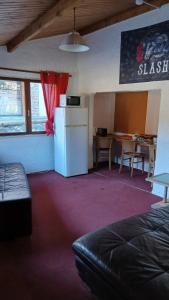 een kamer met een koelkast en een tafel met stoelen bij BodyGo Briançon in Briançon