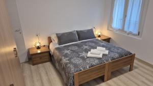 ein Schlafzimmer mit einem großen Bett mit zwei Nachttischen in der Unterkunft Casa Nerina in Calalzo