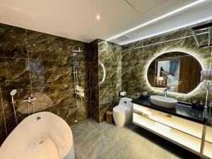 a bathroom with a tub and a sink and a mirror at Royal Hotel Hà Nội in Lưu Phái +68 photos