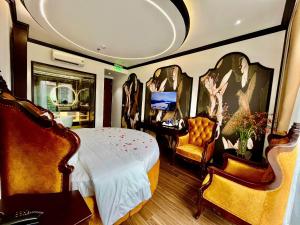 a bedroom with a bed and two chairs at Royal Hotel Hà Nội in Lưu Phái