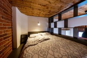 a bedroom with a bed and a brick wall at Apartamente Lux Unirii in Timişoara