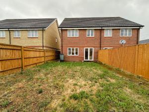 ein Hof vor einem Haus mit einem Zaun in der Unterkunft Heathrow Home - 4BR - Sleeps 6 - Free Parking - Work and Family Friendly in Stanwell