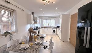 eine Küche und ein Esszimmer mit Tisch und Stühlen in der Unterkunft Heathrow Home - 4BR - Sleeps 6 - Free Parking - Work and Family Friendly in Stanwell