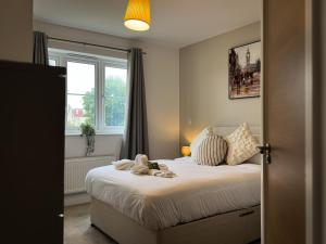 ein Schlafzimmer mit einem Bett mit Schuhen darauf in der Unterkunft Heathrow Home - 4BR - Sleeps 6 - Free Parking - Work and Family Friendly in Stanwell