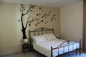 ein Schlafzimmer mit einem Bett und einem Baum mit Vögeln darauf in der Unterkunft Il Poeta - casa accogliente tra Amalfi e Cilento in Battipaglia