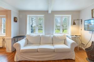 een witte bank in een woonkamer met ramen bij Lüttje Huus 1875 in Almdorf