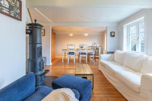 een woonkamer met een witte bank en een houtkachel bij Lüttje Huus 1875 in Almdorf