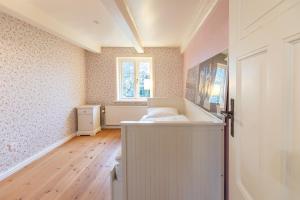 een kleine kamer met een bed en een raam bij Lüttje Huus 1875 in Almdorf +25 foto's