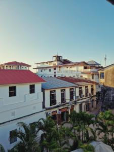 een groep gebouwen in een stad met bomen bij Stone Town Cafe in Zanzibar City