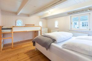 een slaapkamer met twee bedden en een raam bij Lüttje Huus 1875 in Almdorf