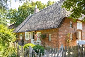 a small brick house with a thatched roof at Lüttje Huus 1875 in Struckum