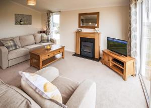 a living room with a couch and a television at Holderness Country Park in Tunstall