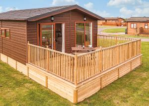 a small house with a wooden porch and a deck at Holderness Country Park in Tunstall