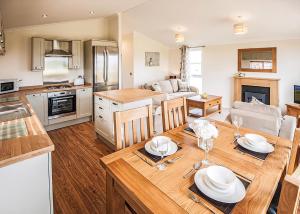 a kitchen and living room with a wooden table with plates on it at Holderness Country Park in Tunstall