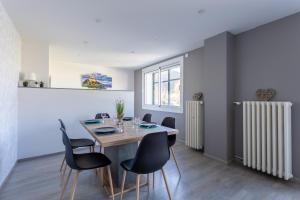 ein Esszimmer mit einem Tisch, Stühlen und einem Heizkörper in der Unterkunft Cocon Savinois - Vue Montagne in Savines + 6 Fotos