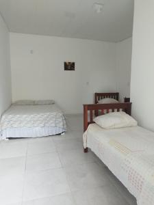 due letti in una stanza con pareti bianche di Hostel dos amigos a Salinópolis