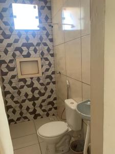 un piccolo bagno con un water e un lavandino di Hostel dos amigos a Salinópolis Altre 4 foto