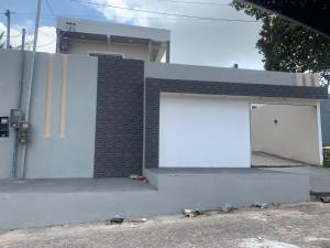 Un edificio con una porta bianca sul lato. di Hostel dos amigos a Salinópolis