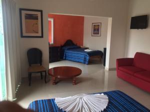 a living room with a bed and a red couch at Casa del Parque Vallarta in Puerto Vallarta