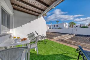 patio con tavolo e sedie sull'erba di SUITE ABORA RELAX a 500m DE LA PLAYA WIFI FIBRA a Puerto del Carmen