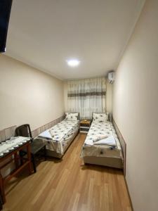 ein Zimmer mit drei Betten und einem Fenster in der Unterkunft Aparmani i sobe Cvetkovic in Sokobanja