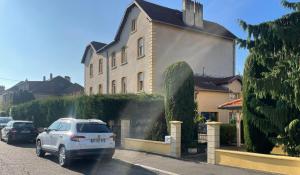 een witte auto geparkeerd voor een huis bij Le Jardin de Phanie, le calme de la campagne en ville in Metz