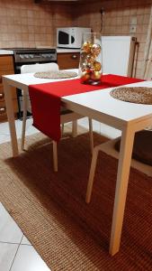 een witte tafel met een rood tafelkleed erop in een keuken bij Skyline Vista - Sea View Apartment with Free Parking in Piraeus