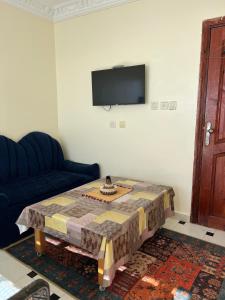 een woonkamer met een tafel en een tv bij Blue Beach Apartments in Taghazout +12 foto's