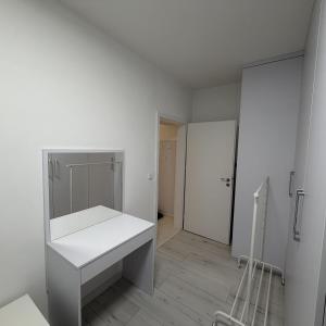 een witte badkamer met een wastafel en een spiegel bij Byt 44m2 Ostrava Bělský les in Hrabŭvka