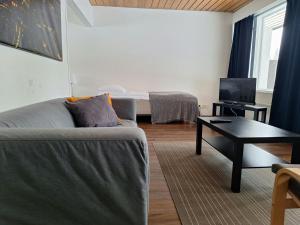 a living room with a couch and a table and a bed at Spacious Apartment for 5 in Sodankylä