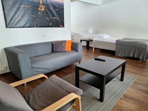 a living room with a couch and a table and a bed at Spacious Apartment for 5 in Sodankylä