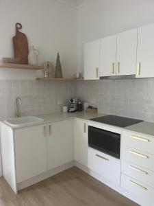 a white kitchen with white cabinets and a sink at Solis in Agnes Water in Agnes Water +12 photos